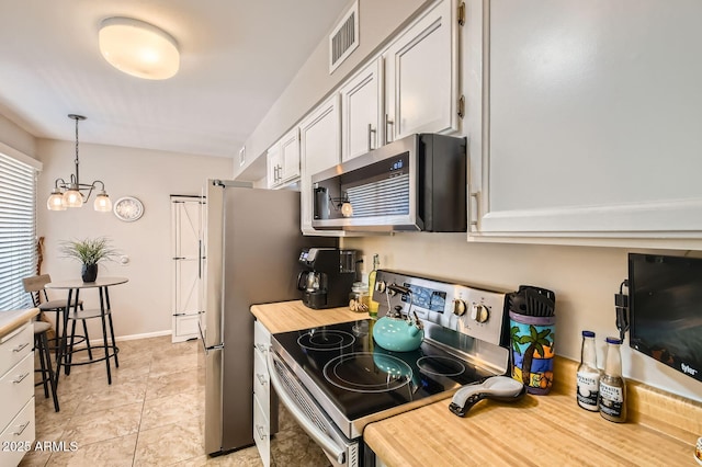 kitchen featuring hanging light fixtures, stainless steel appliances, light countertops, white cabinetry, and visible vents
