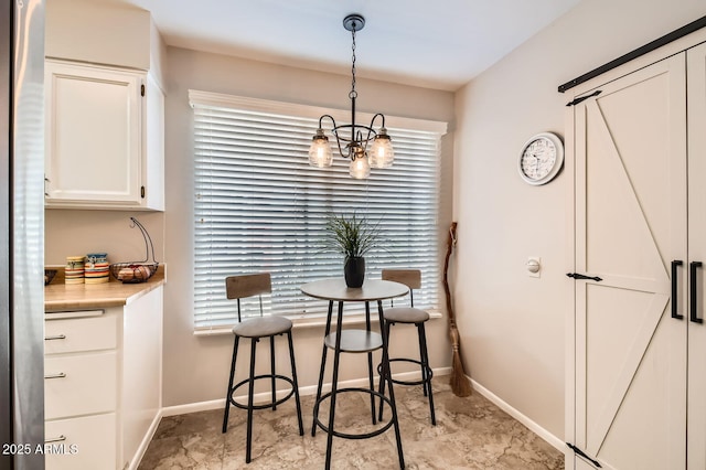 dining room with baseboards and a chandelier