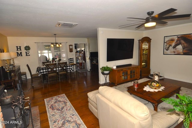 living room with a ceiling fan, wood finished floors, baseboards, and a chandelier
