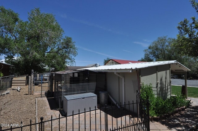 view of property exterior with fence and metal roof