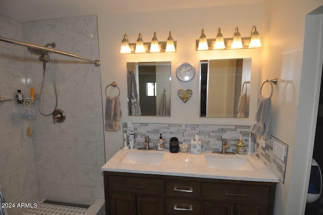 bathroom featuring decorative backsplash, double vanity, and a tile shower