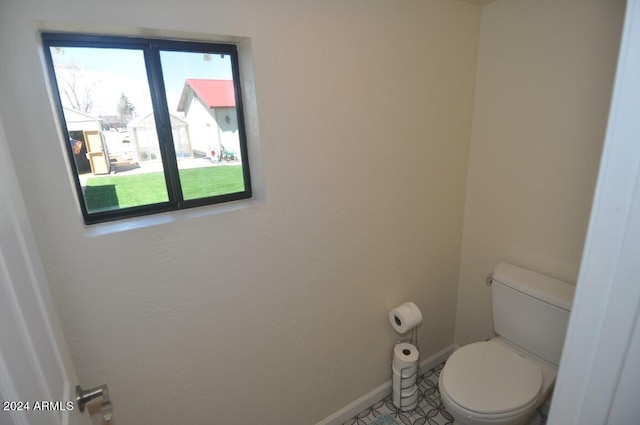 bathroom featuring toilet and baseboards