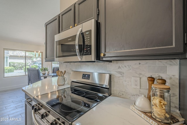 4248 E Jason Dr, Phoenix, AZ 85050 - kitchen featuring stainless steel appliances, backsplash, light countertops, baseboards, and light wood-style flooring