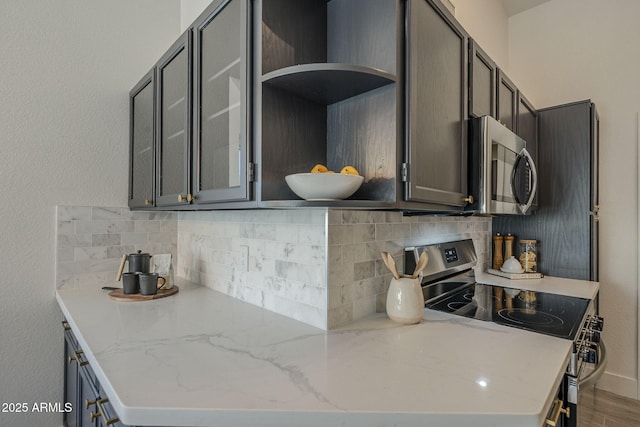 4248 E Jason Dr, Phoenix, AZ 85050 - kitchen featuring appliances with stainless steel finishes, decorative backsplash, open shelves, glass insert cabinets, and light stone countertops