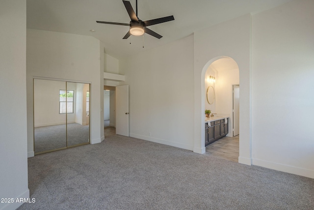 4248 E Jason Dr, Phoenix, AZ 85050 - unfurnished bedroom with light carpet, high vaulted ceiling, arched walkways, and baseboards
