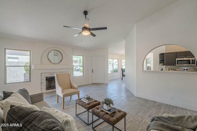 4248 E Jason Dr, Phoenix, AZ 85050 - living room featuring a ceiling fan, baseboards, a fireplace, and light wood-type flooring