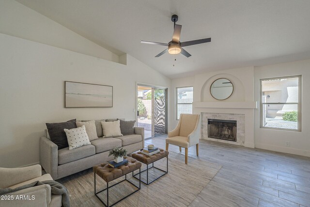 4248 E Jason Dr, Phoenix, AZ 85050 - living room featuring a ceiling fan, lofted ceiling, a tile fireplace, wood finished floors, and baseboards
