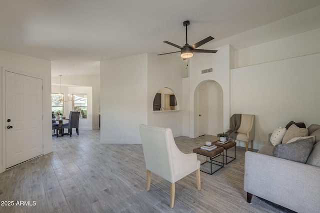 4248 E Jason Dr, Phoenix, AZ 85050 - living area with arched walkways, wood finished floors, a chandelier, a ceiling fan, and baseboards