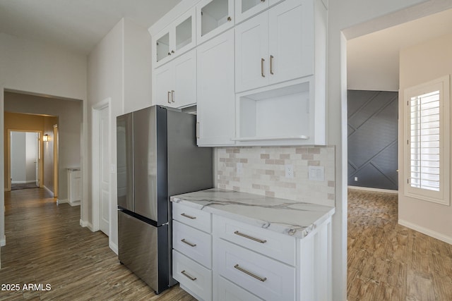 1826 W Oriole Way, Chandler, AZ 85286 - kitchen with freestanding refrigerator, light stone countertops, glass insert cabinets, white cabinetry, and wood finished floors