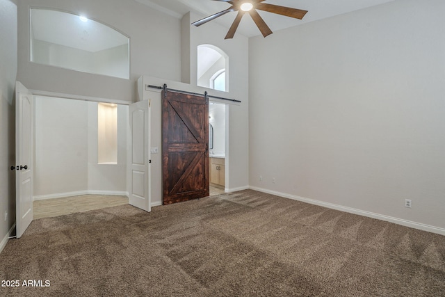 1826 W Oriole Way, Chandler, AZ 85286 - unfurnished bedroom with carpet, a barn door, a towering ceiling, ceiling fan, and ensuite bathroom