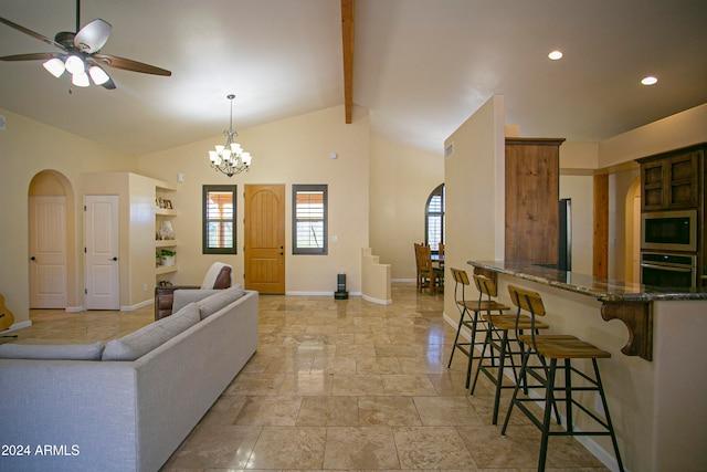 living room with beam ceiling, high vaulted ceiling, and ceiling fan with notable chandelier