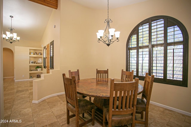 dining space with an inviting chandelier, high vaulted ceiling, and built in shelves