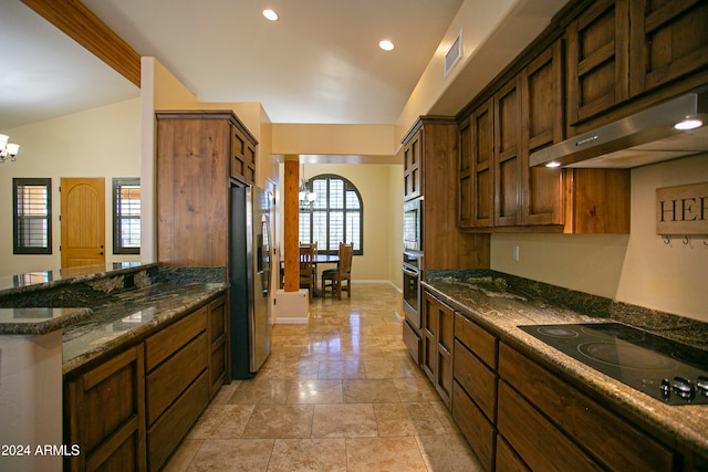 kitchen featuring vaulted ceiling, stainless steel appliances, an inviting chandelier, and dark stone countertops