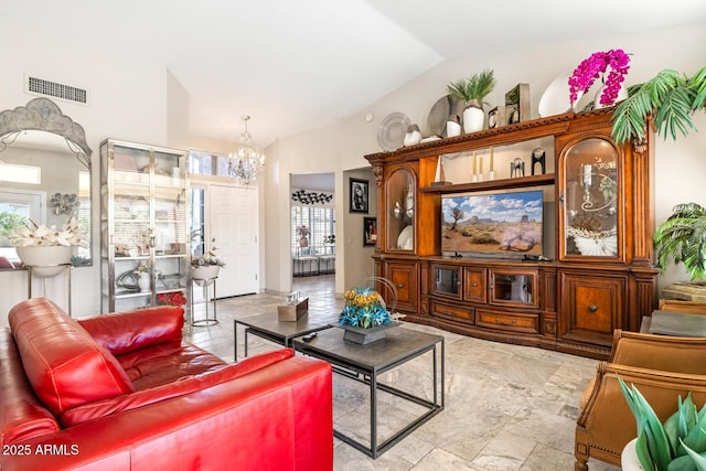 living area with visible vents, vaulted ceiling, and a notable chandelier