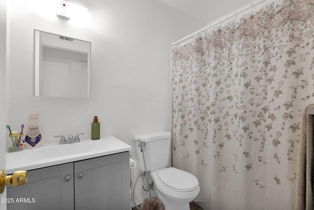 bathroom featuring a shower with curtain, vanity, and toilet