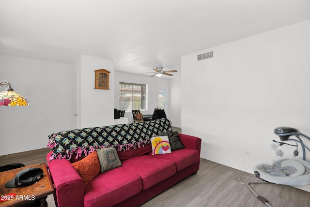 living room featuring visible vents, ceiling fan, and wood finished floors