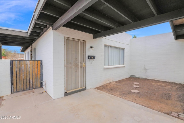 doorway to property featuring a patio area and concrete block siding