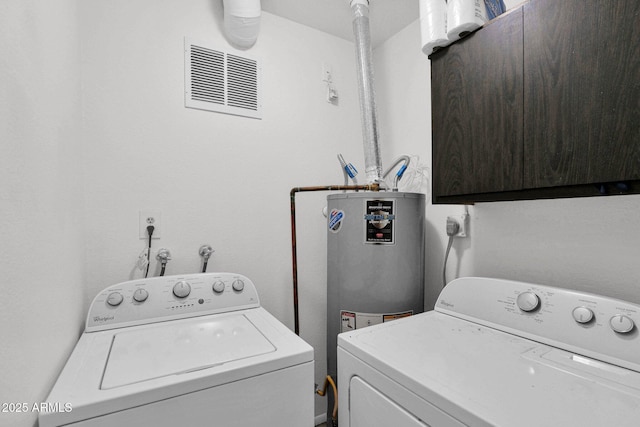 laundry area featuring visible vents, gas water heater, washing machine and dryer, and cabinet space