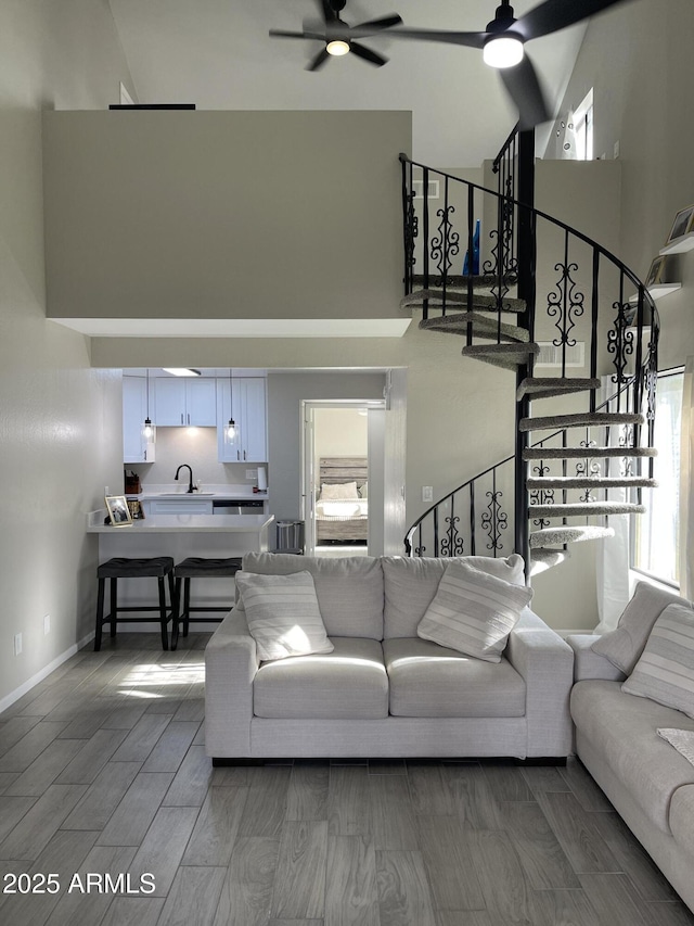 living room with sink, a towering ceiling, and ceiling fan