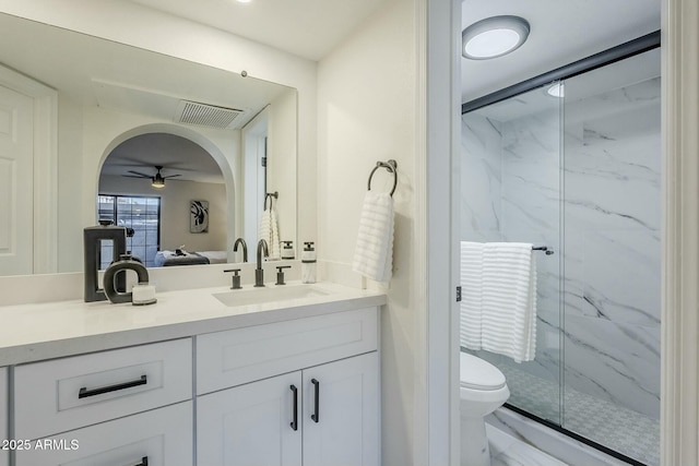 bathroom featuring an enclosed shower, vanity, toilet, and ceiling fan