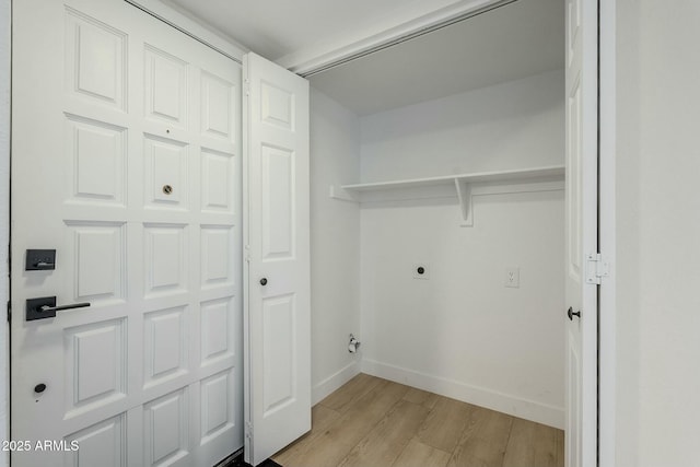 clothes washing area featuring electric dryer hookup and light wood-type flooring