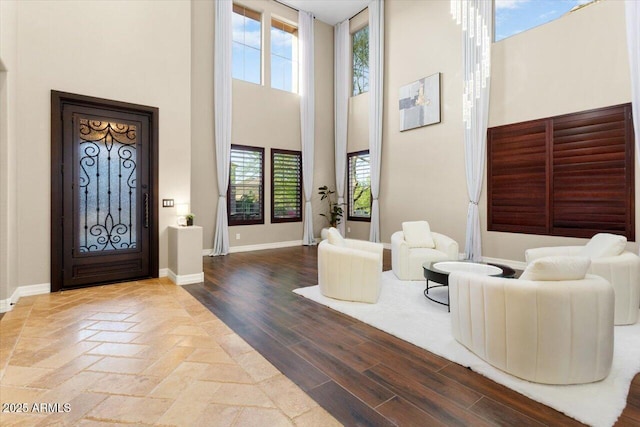 foyer entrance with hardwood / wood-style floors and a high ceiling