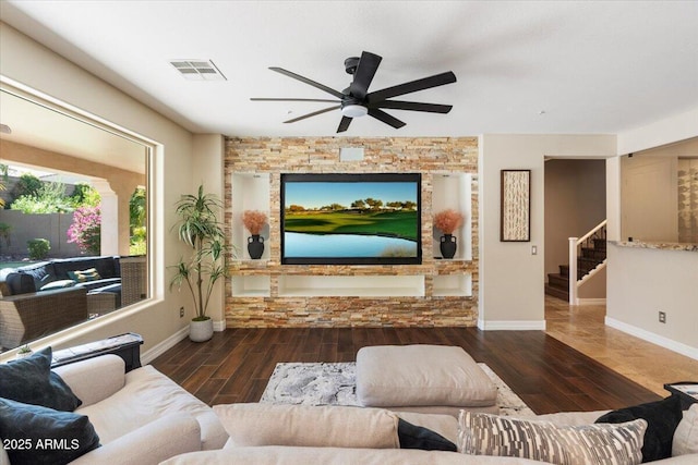 living room with ceiling fan, stairs, visible vents, and wood finished floors