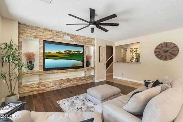 living room featuring ceiling fan, stairway, baseboards, and wood tiled floor