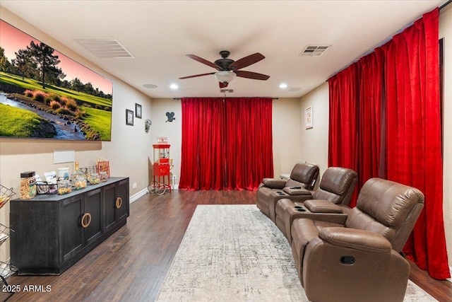 home theater featuring dark wood finished floors, visible vents, and a ceiling fan