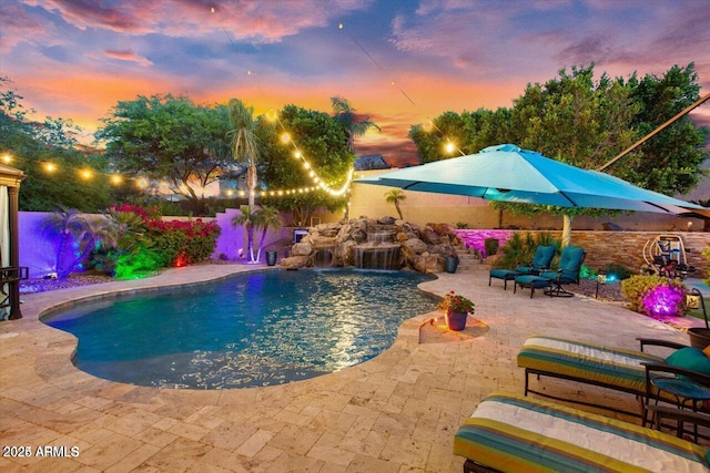 pool at dusk with a patio area, a fenced backyard, and a fenced in pool