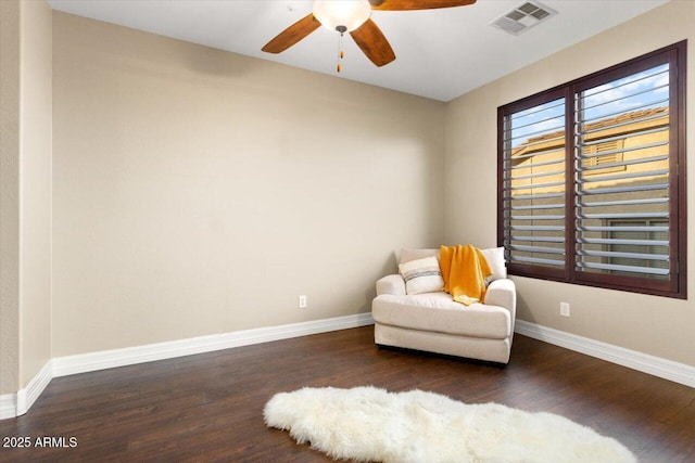 living area featuring visible vents, ceiling fan, baseboards, and wood finished floors