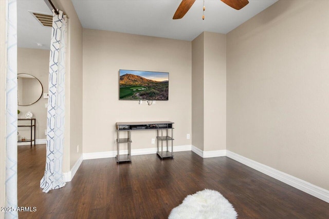 unfurnished living room featuring dark wood-type flooring and ceiling fan