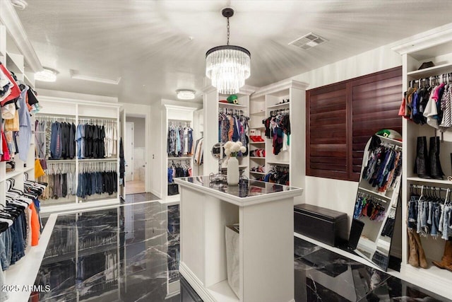 walk in closet featuring marble finish floor, visible vents, and a notable chandelier