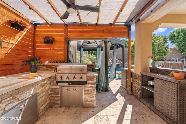 view of patio with ceiling fan, area for grilling, and grilling area