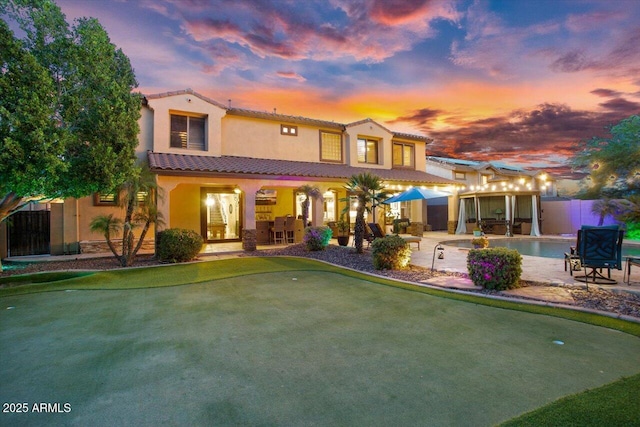 mediterranean / spanish-style home with a fenced in pool, a patio, fence, and stucco siding