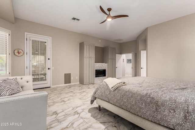 bedroom with visible vents, marble finish floor, a fireplace, access to exterior, and a ceiling fan