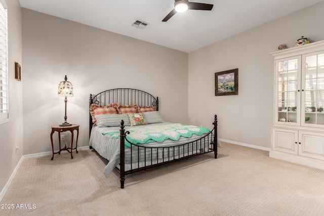 bedroom with visible vents, baseboards, multiple windows, and light colored carpet