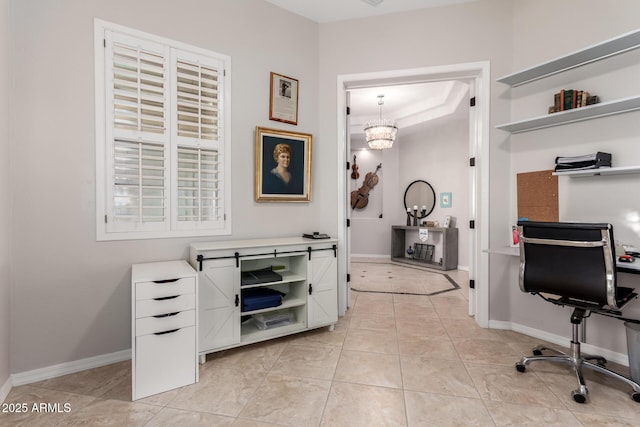 office space featuring baseboards, an inviting chandelier, light tile patterned floors, and a raised ceiling