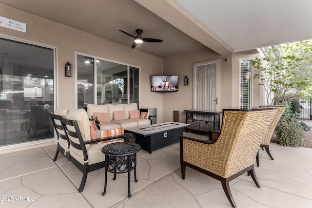 view of patio with ceiling fan and an outdoor living space with a fire pit