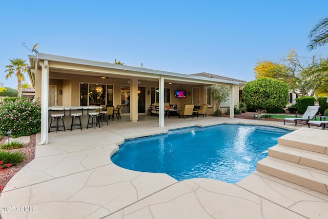 view of swimming pool with a patio, a fenced in pool, and outdoor dry bar