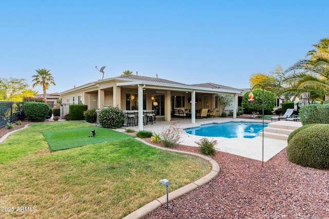 view of pool with an outdoor living space, a lawn, a patio area, fence, and a fenced in pool