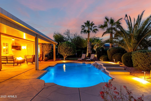 pool at dusk with a patio and an outdoor pool