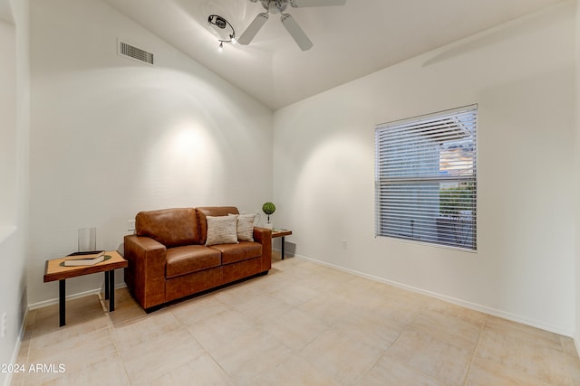 living area with lofted ceiling, light tile patterned floors, and ceiling fan