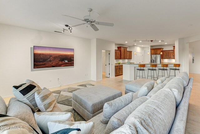 living room featuring light hardwood / wood-style flooring and ceiling fan