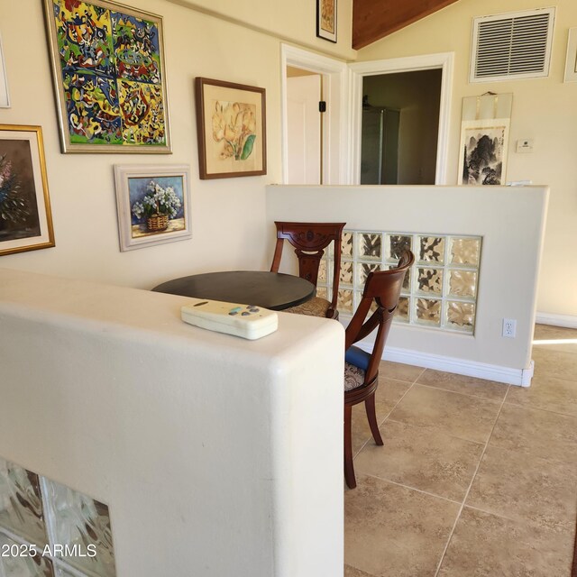 tiled dining room with baseboards and lofted ceiling