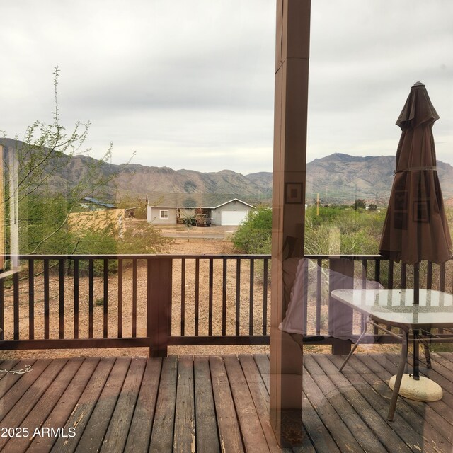 wooden deck with a mountain view and outdoor dining space