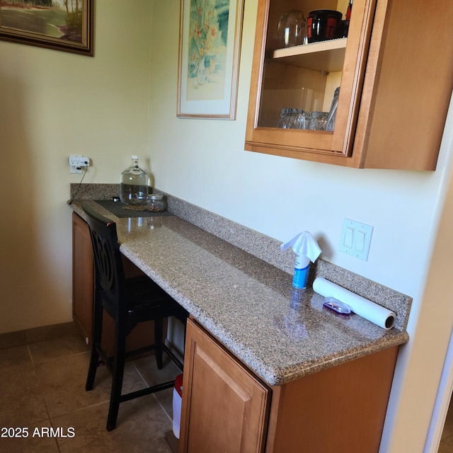 bar area featuring dark tile patterned flooring and baseboards