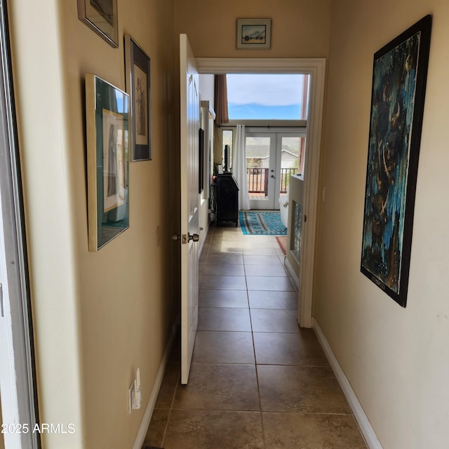 hallway featuring french doors, baseboards, and tile patterned floors