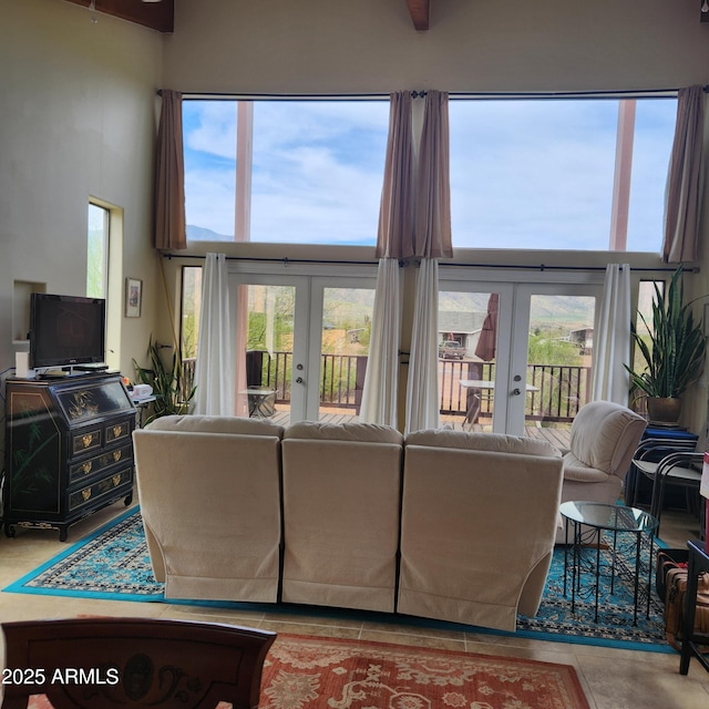 living room with french doors, healthy amount of natural light, and a high ceiling