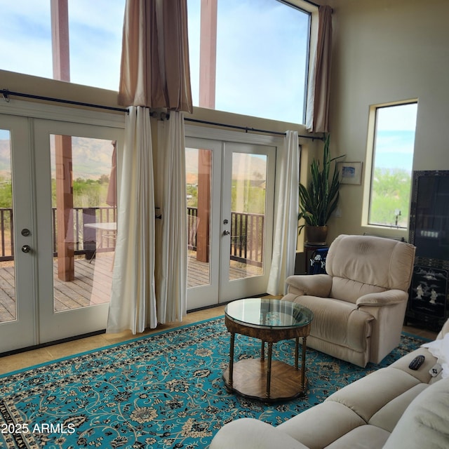 living area with french doors and a towering ceiling